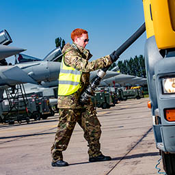 RAF Driver unwinding fuel hose from fuel truck in front of line of Typhoon jets