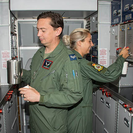 RAF Air & Ground Stewards in flying suits preparing hot drinks in aircraft galley
