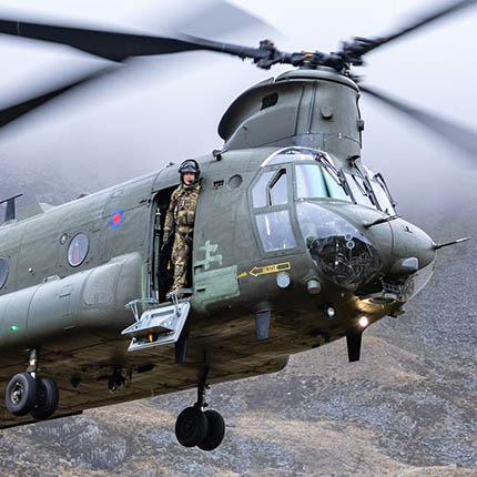 RAF Weapon Systems Operator (Crewman) at door of hovering Chinook helicopter in Snowdonia on Exercise Kukri Dawn.
