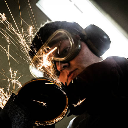 RAF General Technician (Workshops) using grinder on metal, wearing protective equipment
