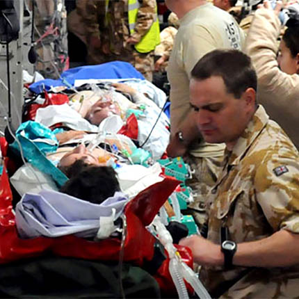RAF Medical Support Officer attending to casualty on stretch inside medically equipped aircraft