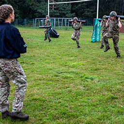 RAF Physical Training Instructor supervises a log race for RAF Technicians.