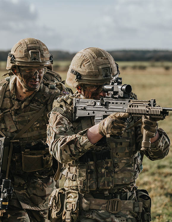 RAF Regiment Gunner with SA80 rifle under instruction on firing range